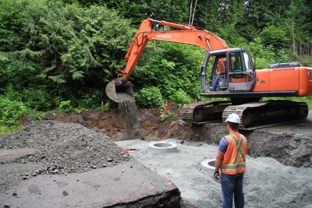 Adding road base to stabilize bank at end of culvert.